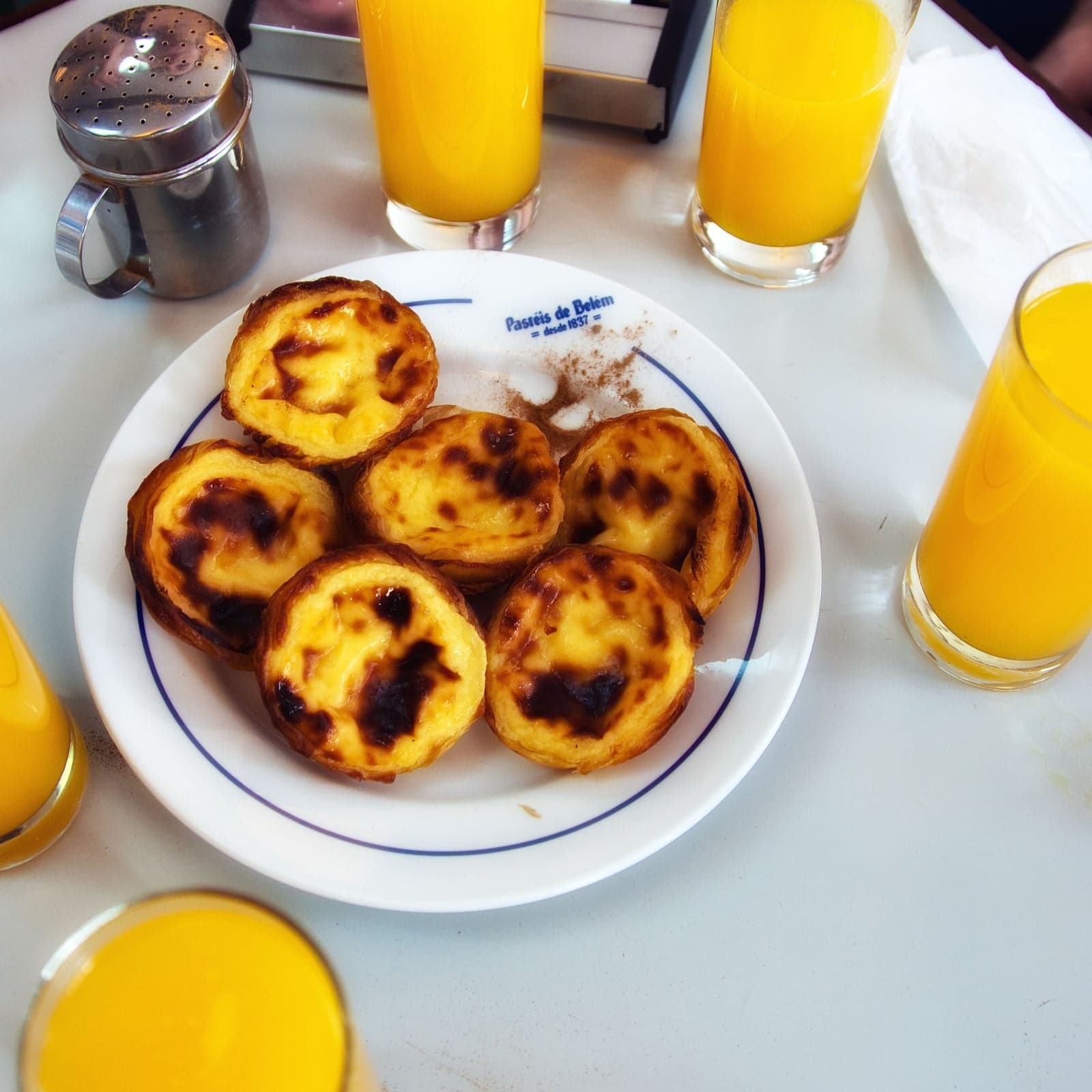 A row of golden pastel de nata custard tarts on a tray