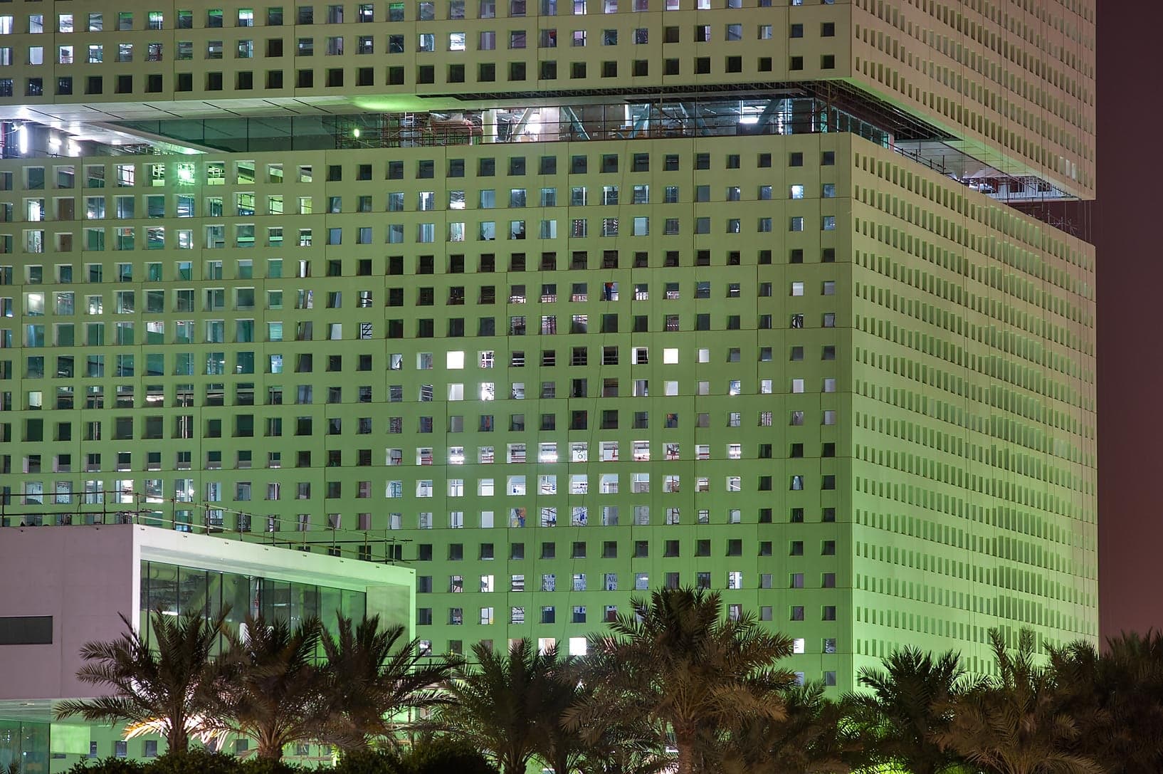 The striking angular glass building of Education City's Qatar National Library surrounded by greenery