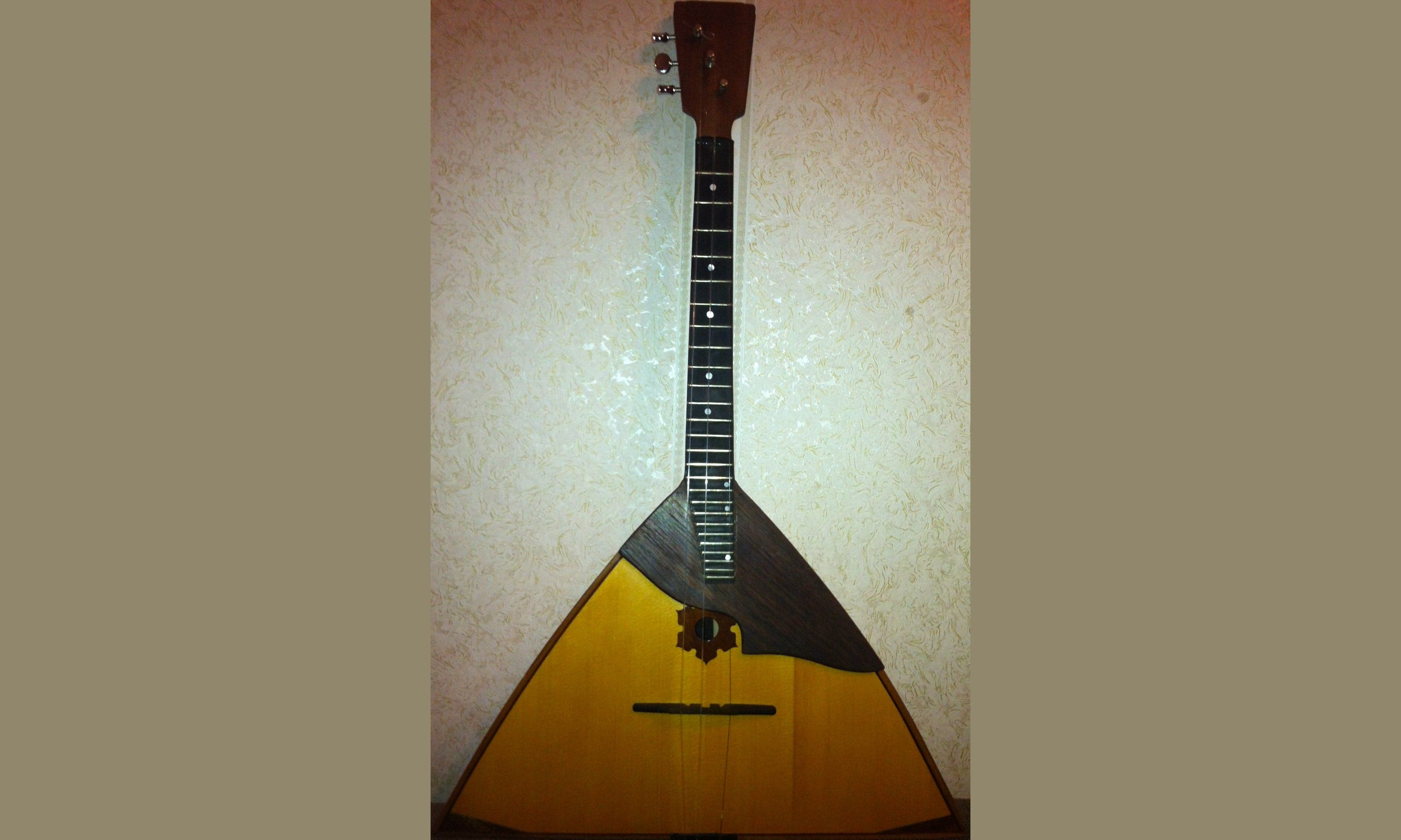 A wooden balalaika with its distinctive triangular body and three strings