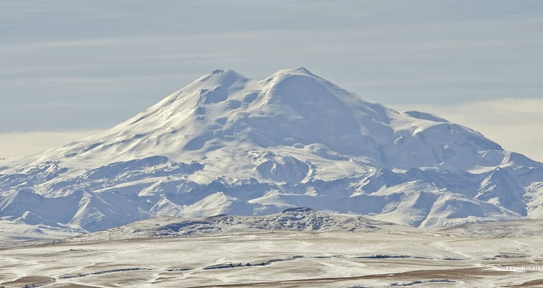 The snow-capped twin peaks of Mount Elbrus rising above the Caucasus Mountains