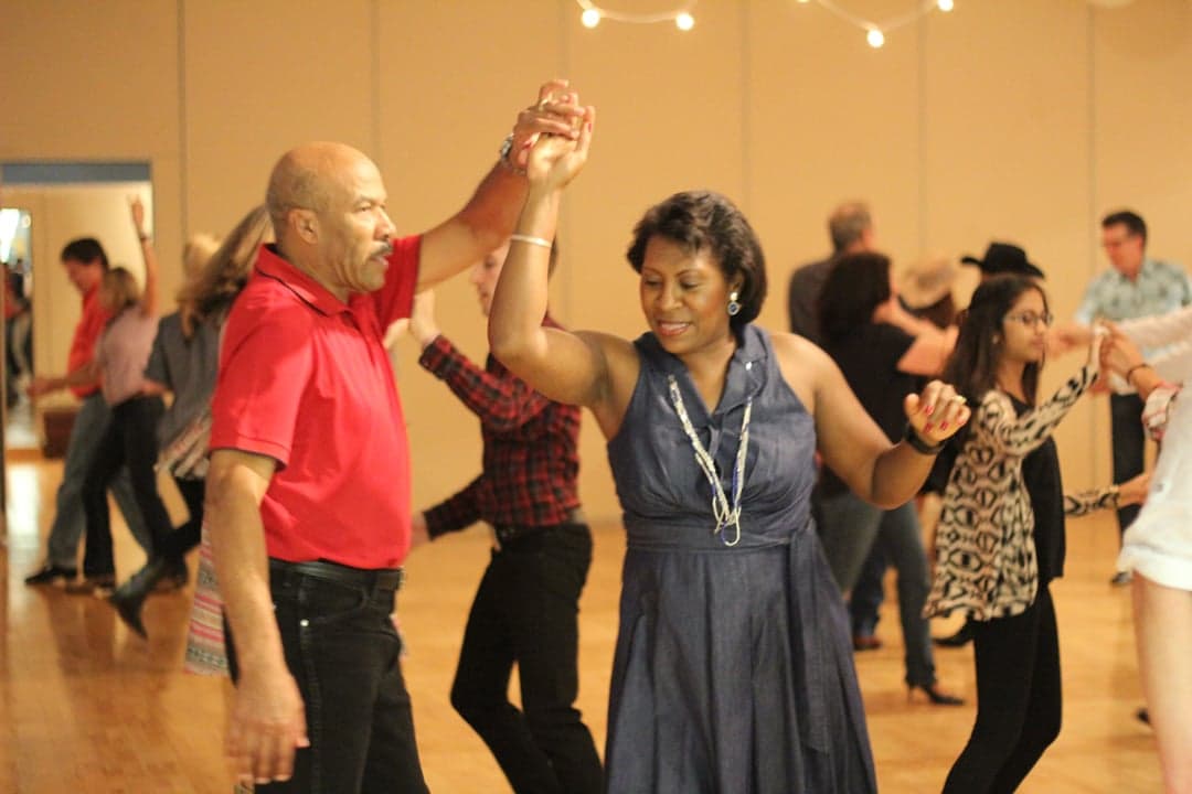 Couples dancing zouk at a Caribbean music event with colourful lights