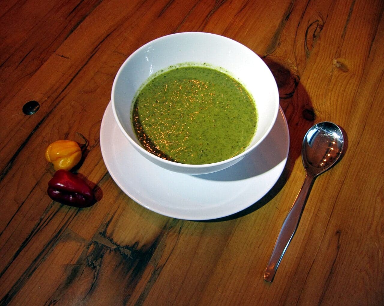 A bowl of thick green callaloo soup with dumplings