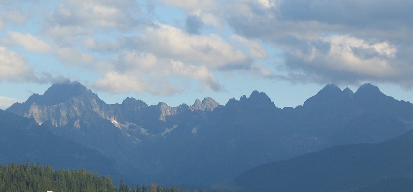 The jagged peaks of the High Tatras reflected in a clear mountain lake