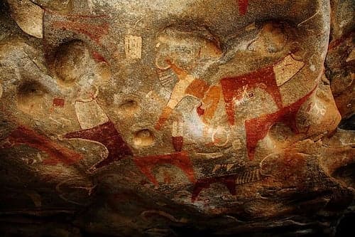 Brightly coloured ancient rock paintings of cattle and people inside a cave at Laas Geel