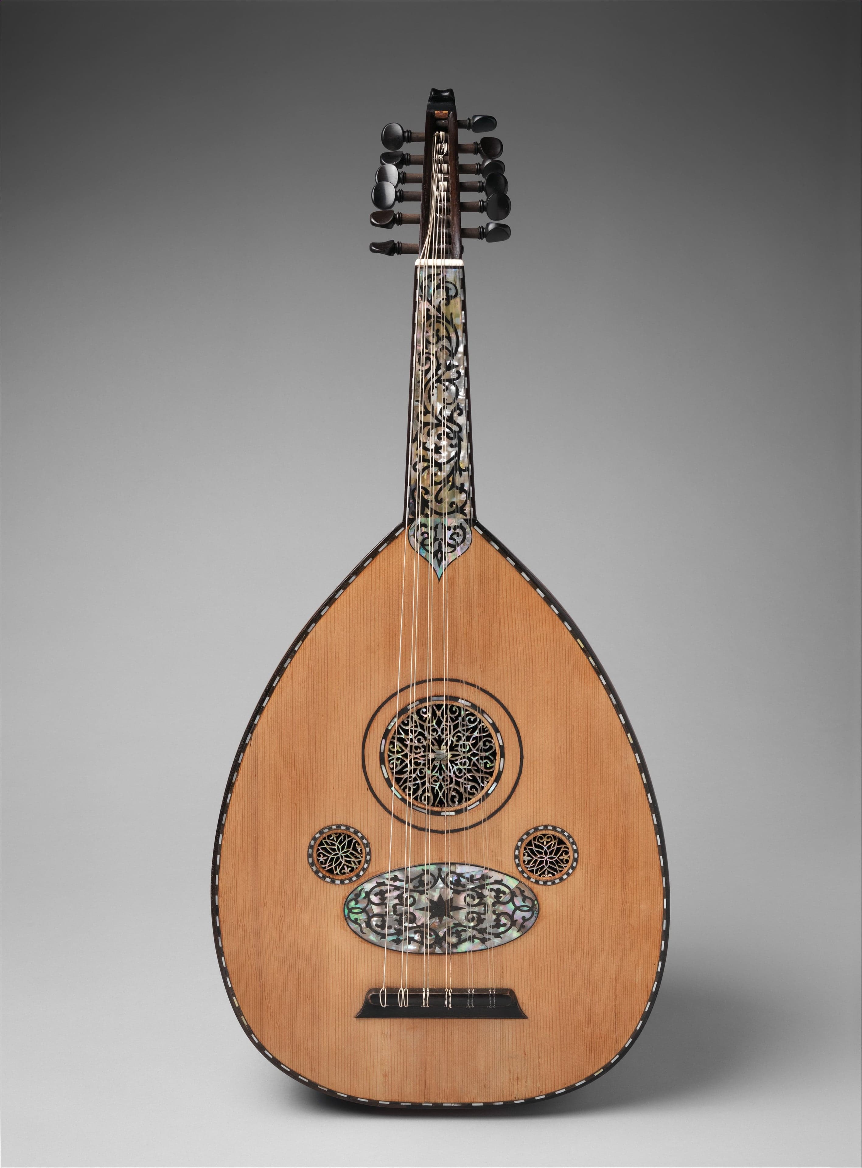 A polished wooden oud instrument with intricate sound hole decorations