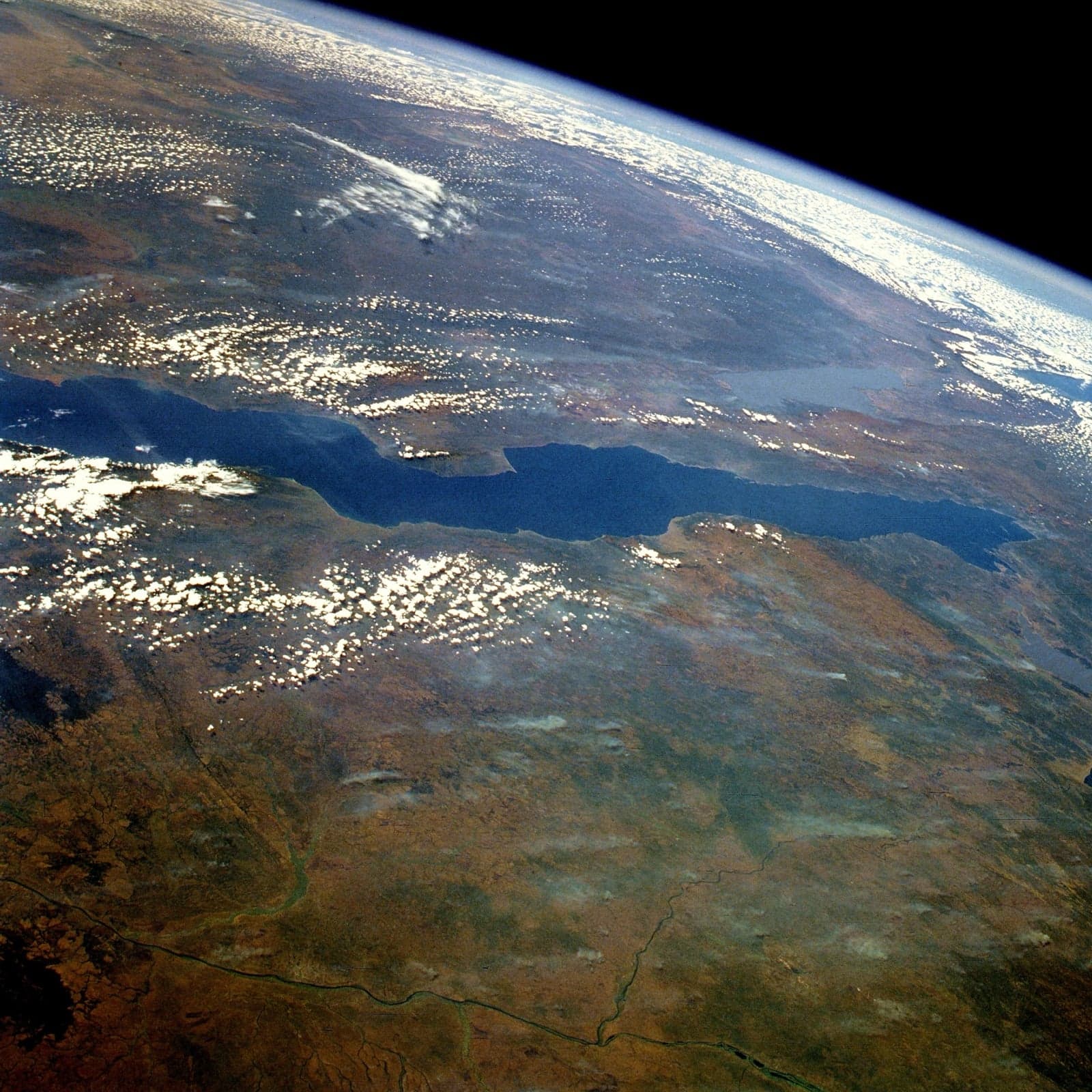 The calm blue surface of Lake Tanganyika seen from the Tanzanian shore