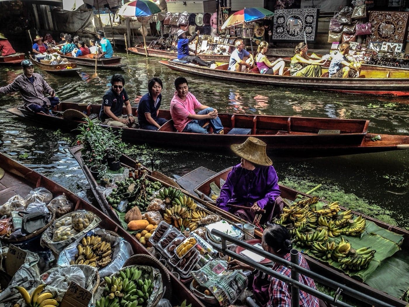 Boats piled high with bananas and bright fruit at a floating market in Thailand