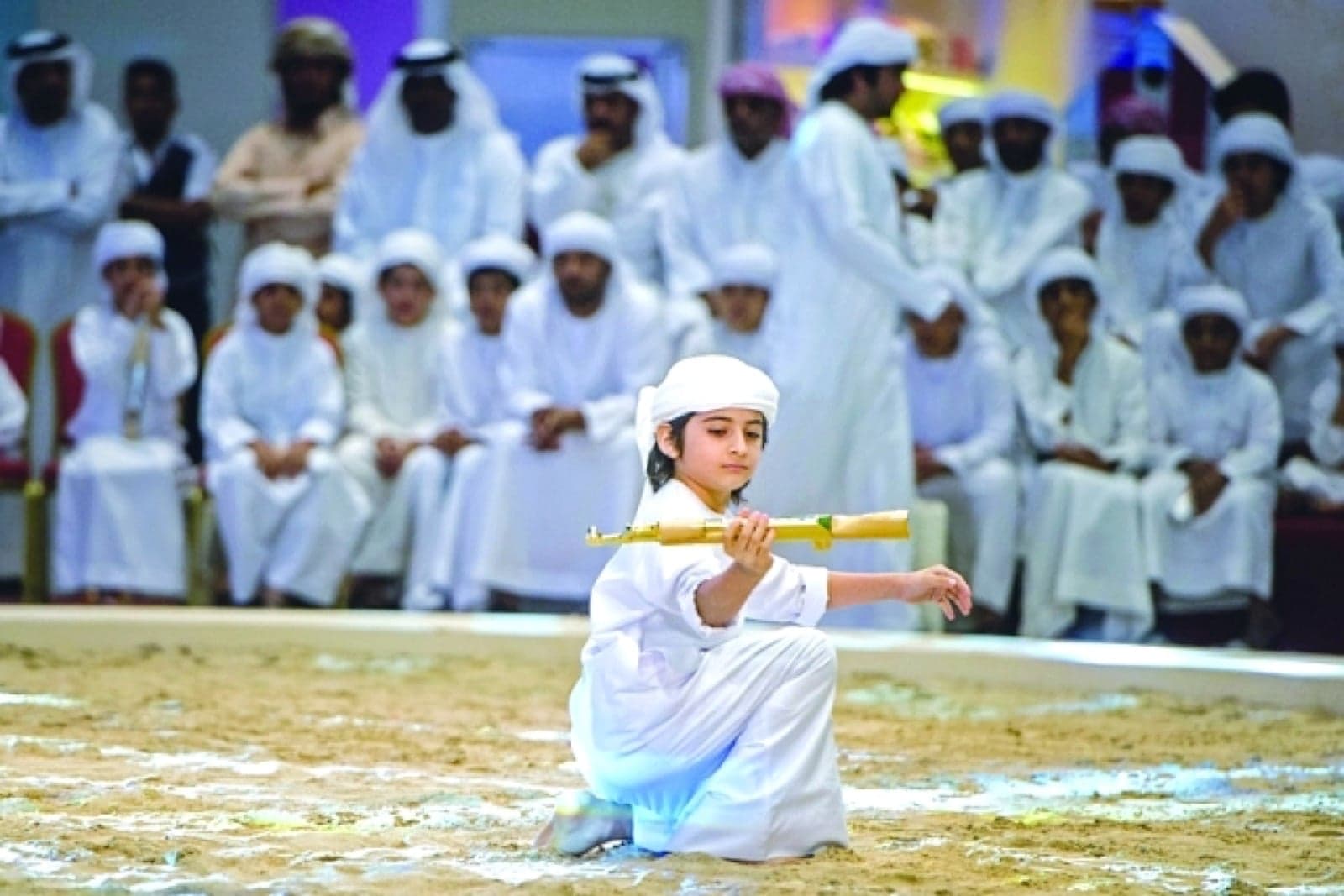 Performers in long white robes performing the Al-Ayyala dance with sticks