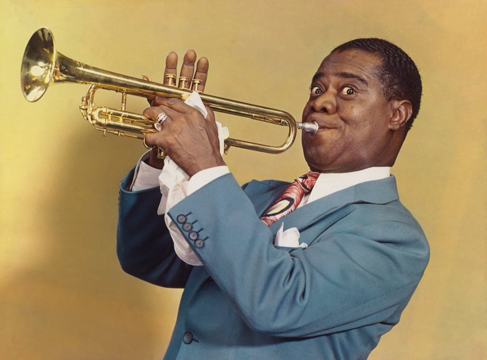 Louis Armstrong playing a brass trumpet