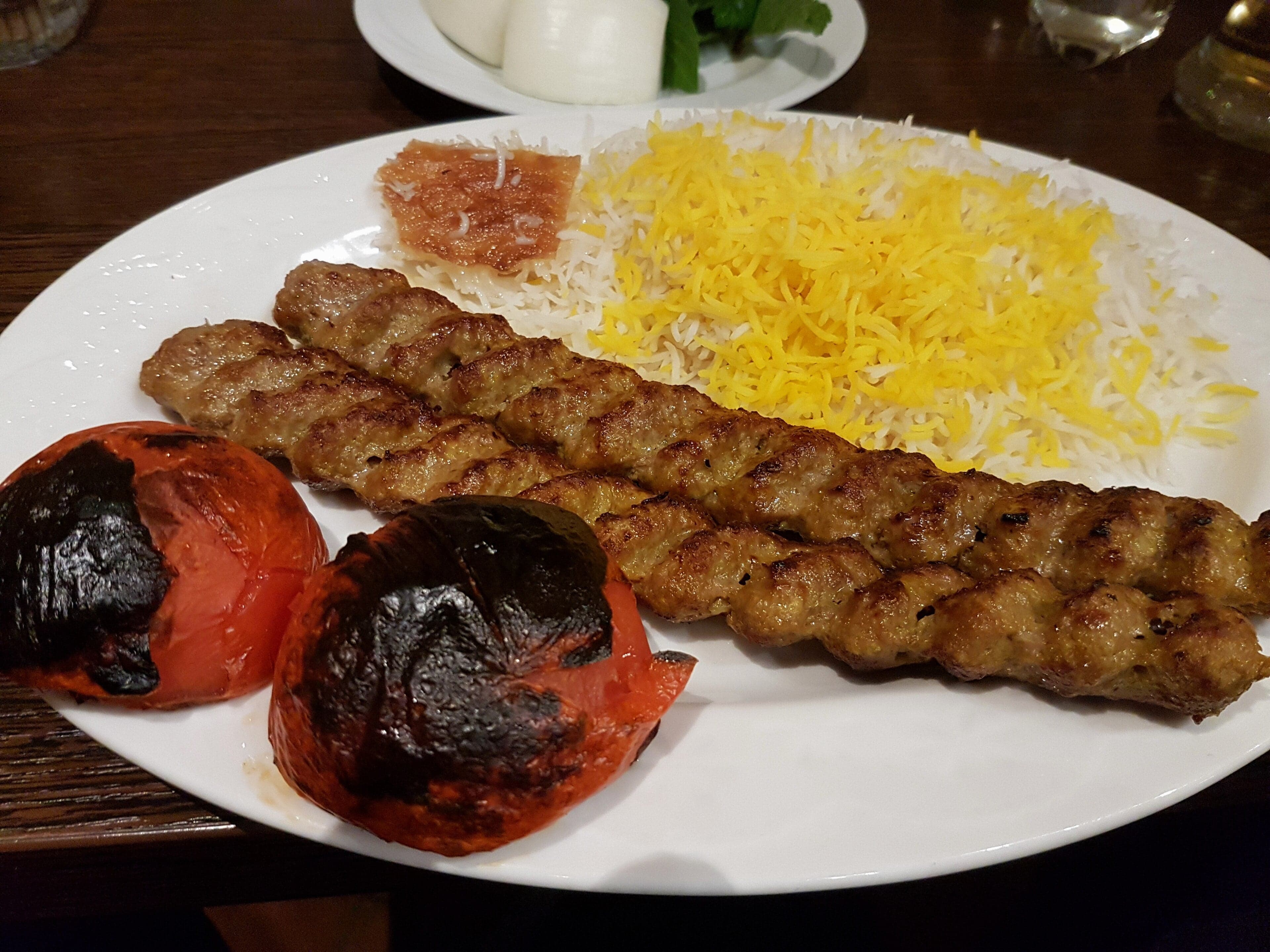 Skewers of grilled meat called shashlik over glowing coals