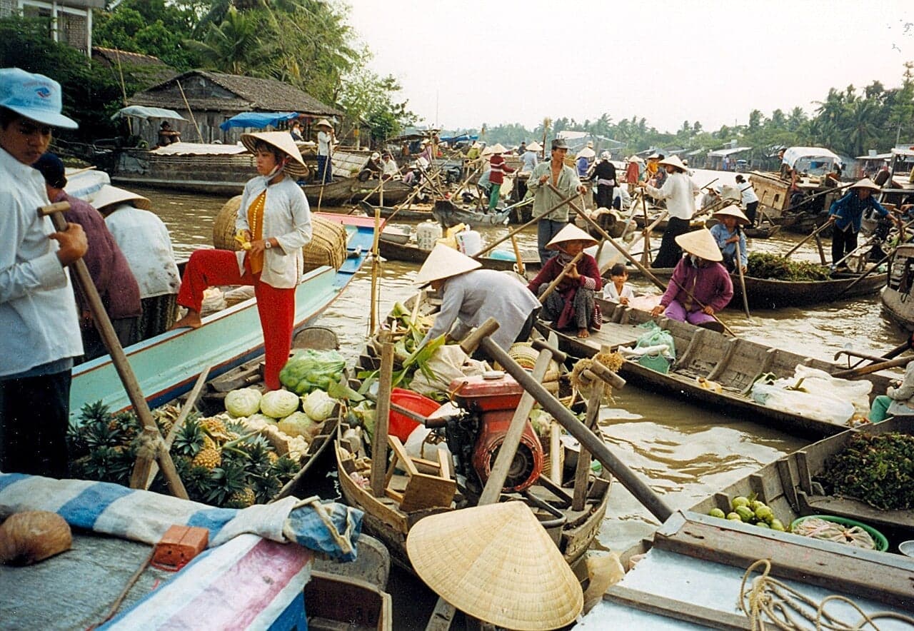 A busy floating market on the Mekong Delta, with dozens of wooden boats piled with fruit and vegetables