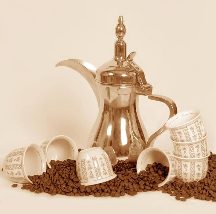 Colourful bags and bowls of Yemeni coffee beans on display at a market stall with people tasting samples