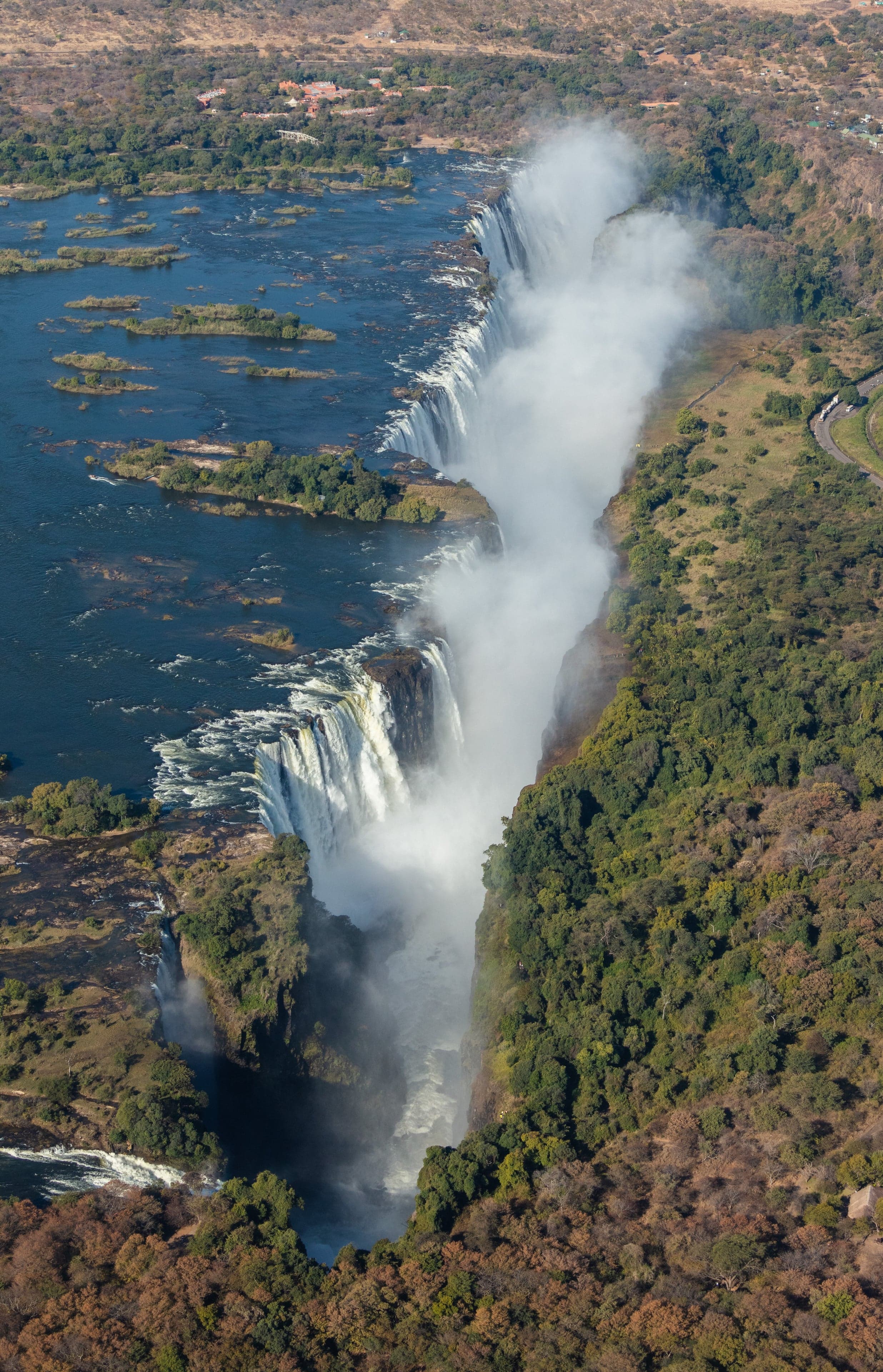 The vast curtain of Victoria Falls with rising mist over the Zambezi River