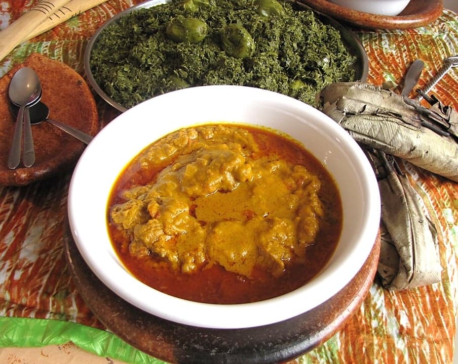Bowl of smooth white funje cassava porridge served with a rich stew