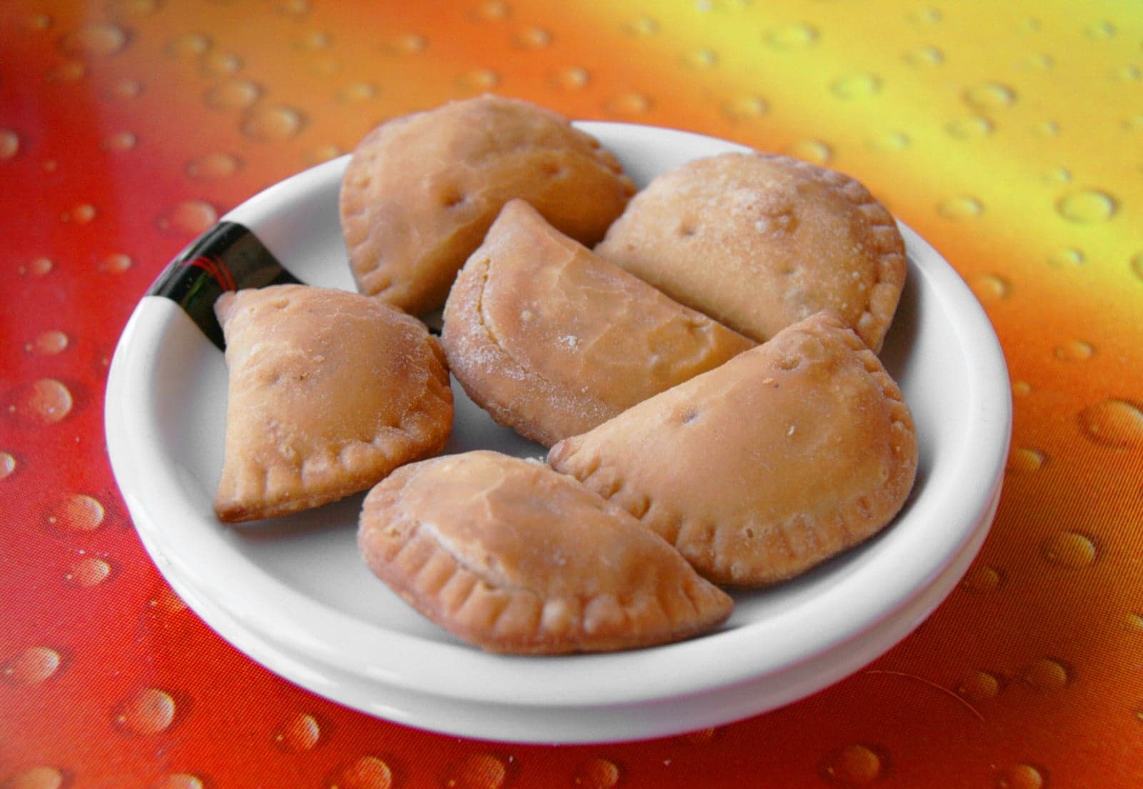A plate of golden baked empanadas