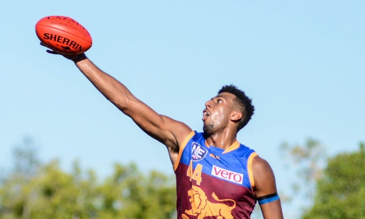 An AFL player leaping high to take a 'mark' over another player