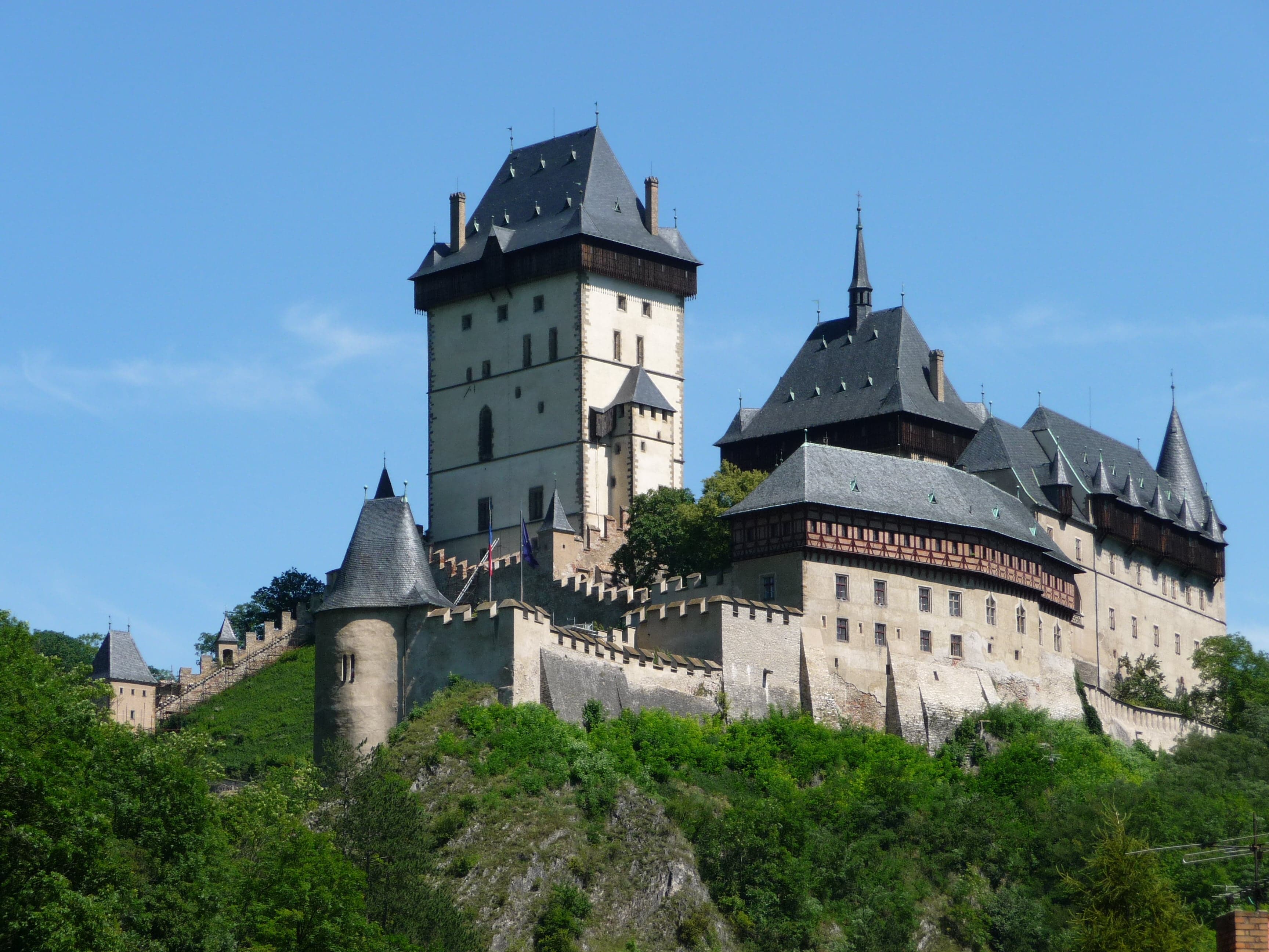 Karlštejn Castle rising above autumn forests on a steep rocky ridge