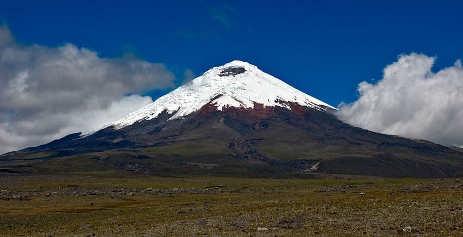 Cotopaxi volcano rising above the Andean plain, its perfect cone dusted with snow