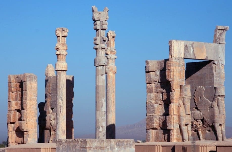Tall stone columns and carved reliefs at the ruins of Persepolis