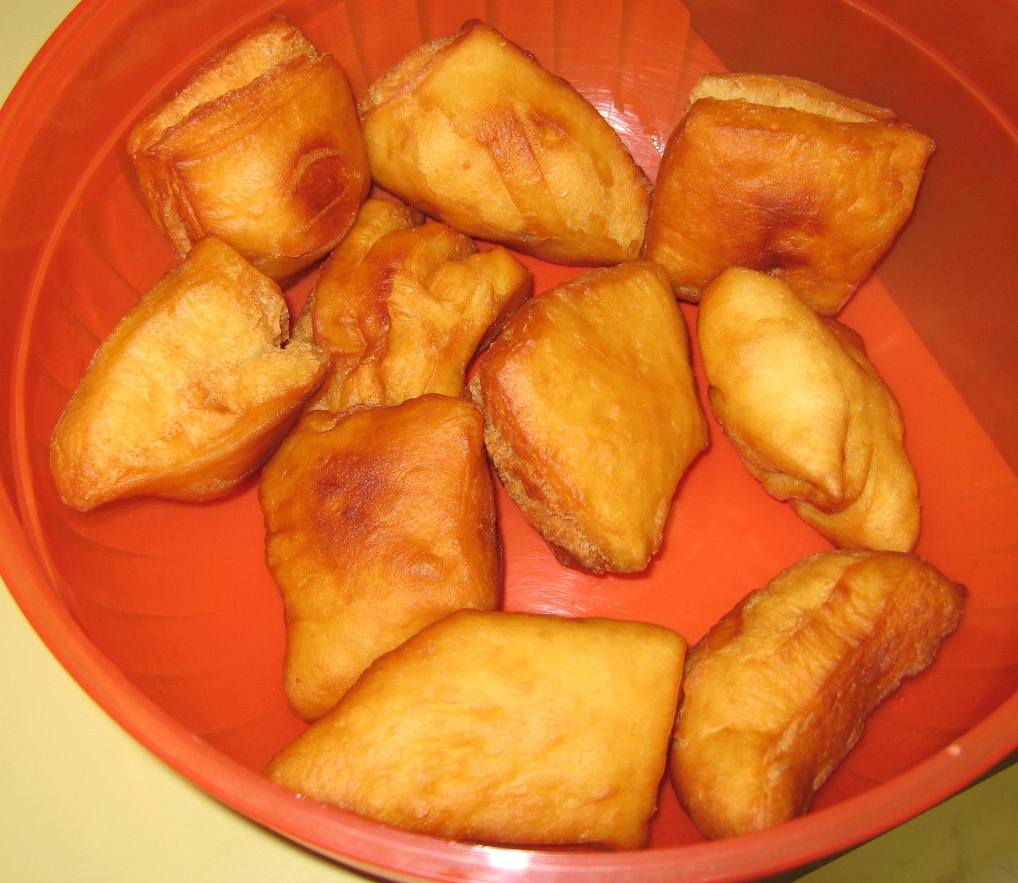 A pile of golden, puffy baursak dough balls on a traditional Kazakh cloth