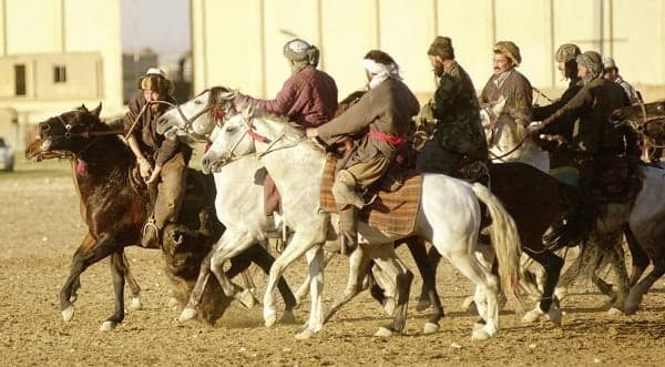 Kokpar riders on horseback competing at a traditional Kazakh festival on open steppe