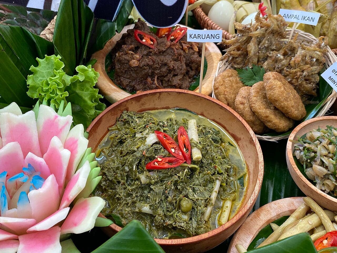 A bowl of deep green Liberian cassava leaf stew served alongside white rice