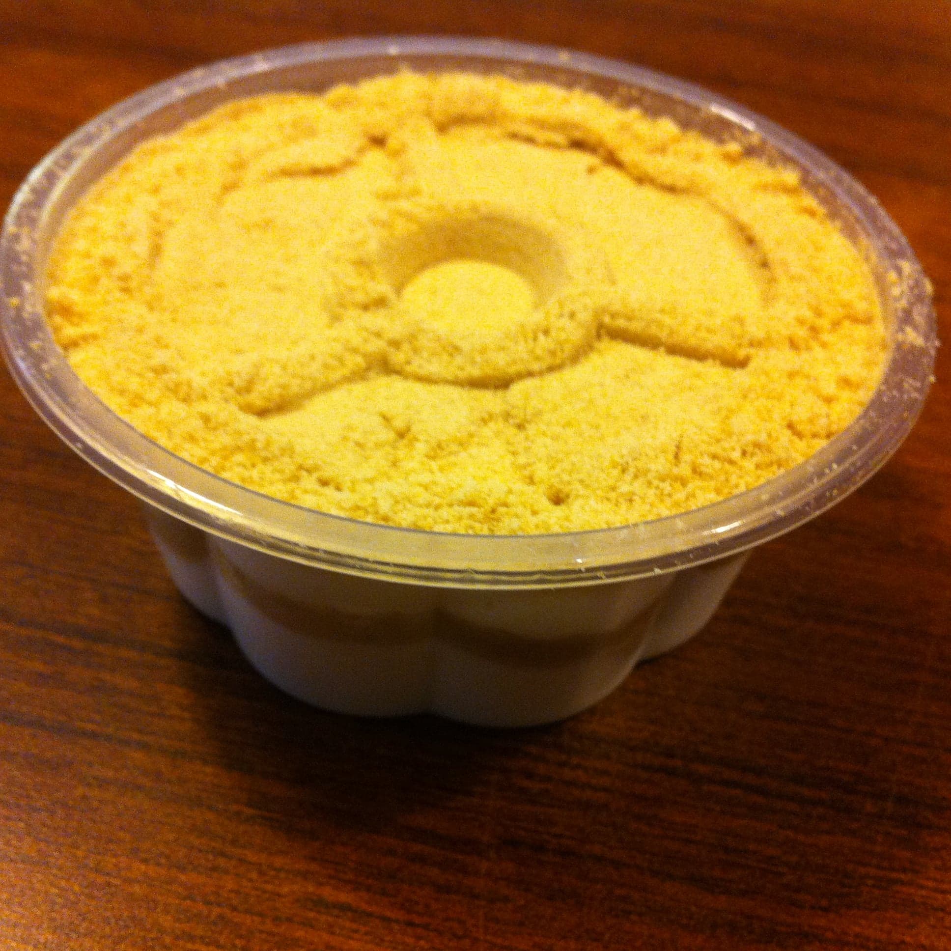 A glass cup of creamy serradura pudding with biscuit crumbs on top