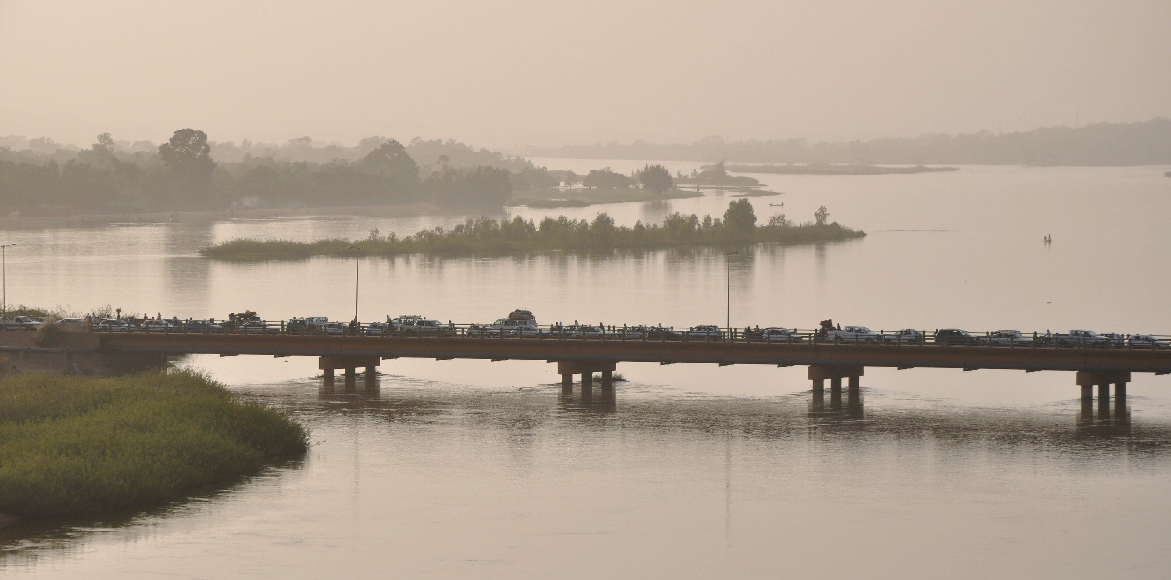 Wooden fishing pirogues on the wide, shimmering Niger River at dawn