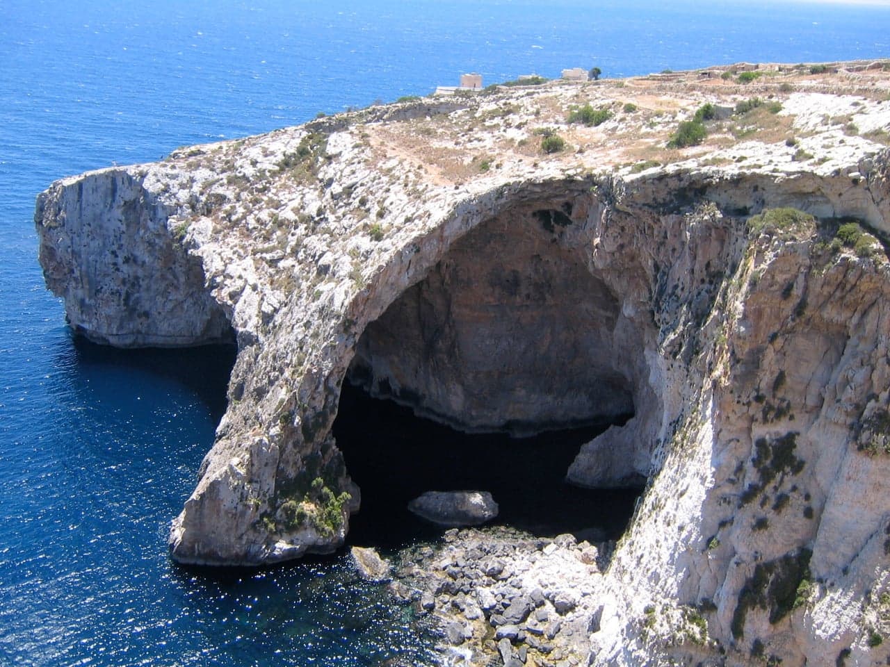 A natural sea arch over bright blue water at Malta's Blue Grotto
