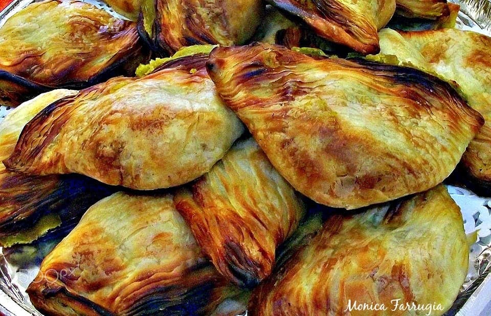 A tray of golden flaky Maltese pastizzi pastries