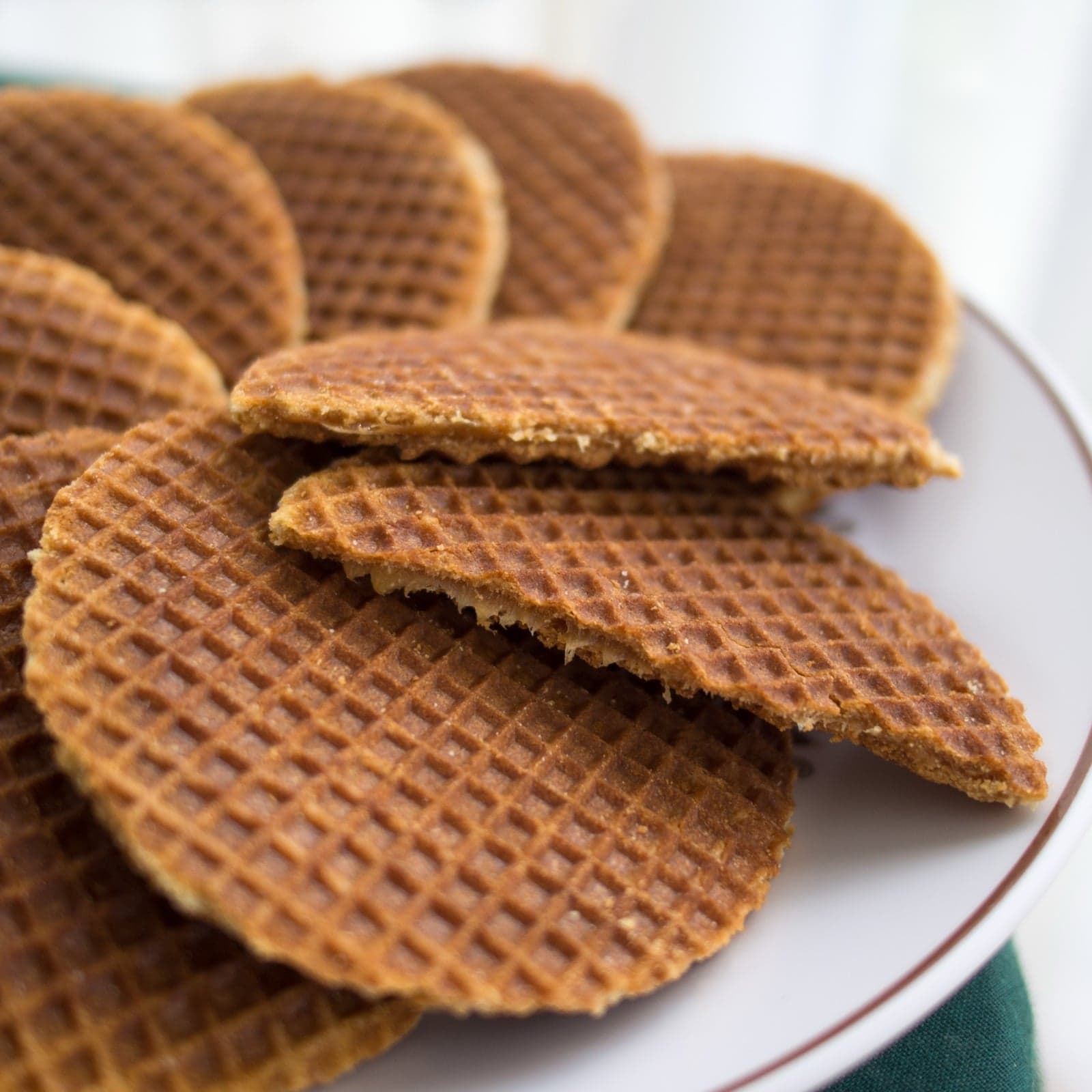 A stack of round stroopwafels with golden syrup oozing between two thin waffle layers