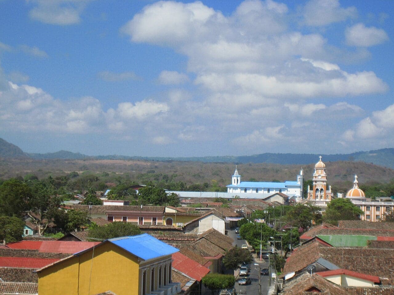 Brightly painted colonial buildings lining a cobblestone street in Granada, Nicaragua