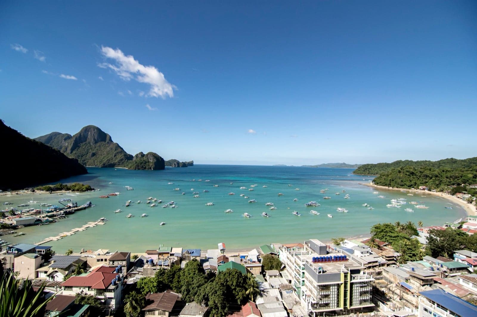 A turquoise bay dotted with boats and limestone islands in El Nido, Palawan