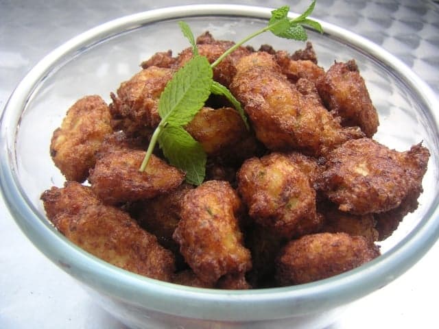 Golden-brown crispy saltfish accra fritters piled on a plate