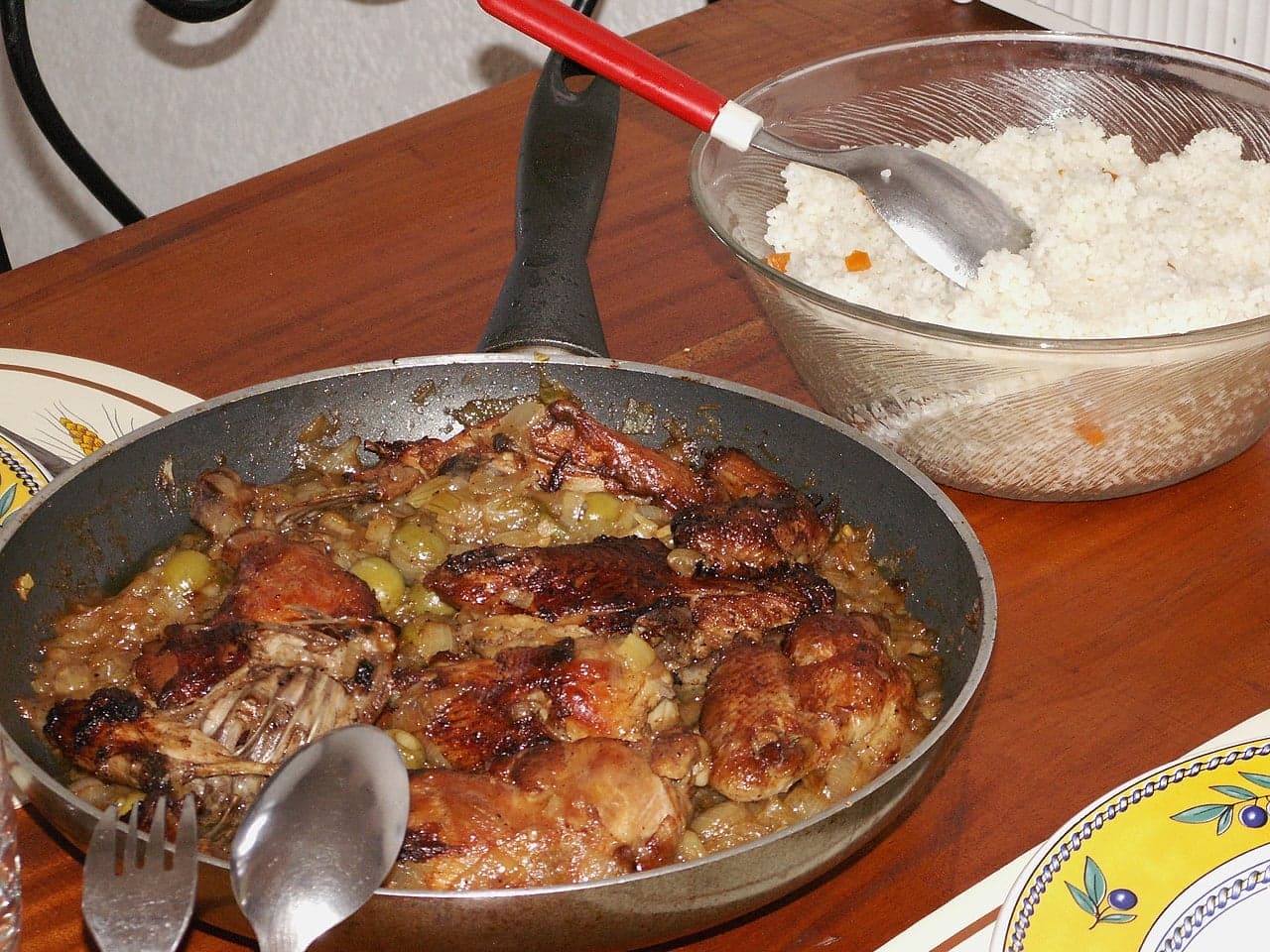A plate of yassa chicken with caramelised onions over white rice