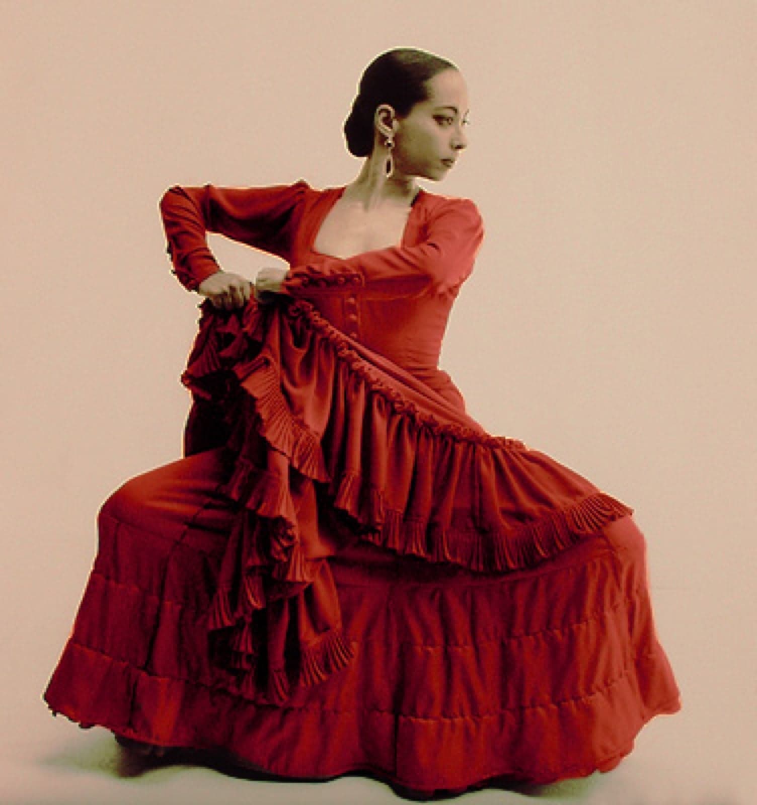A flamenco dancer in a red dress mid-pose