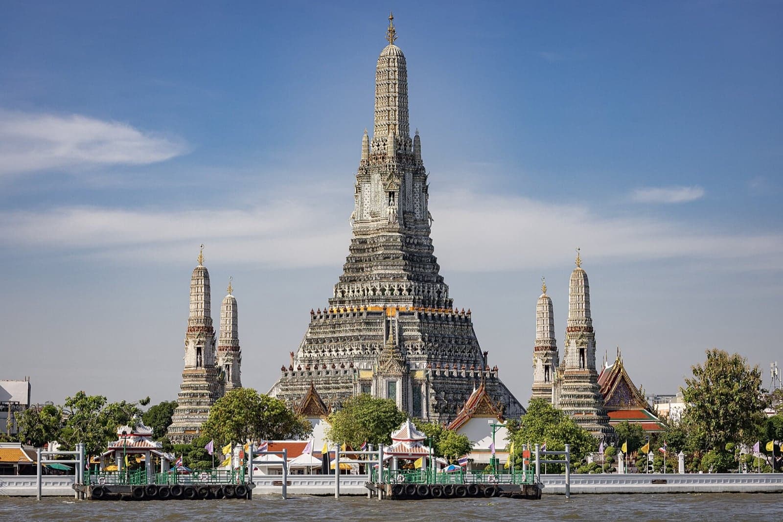 The white spire of Wat Arun temple rising over the river in Bangkok