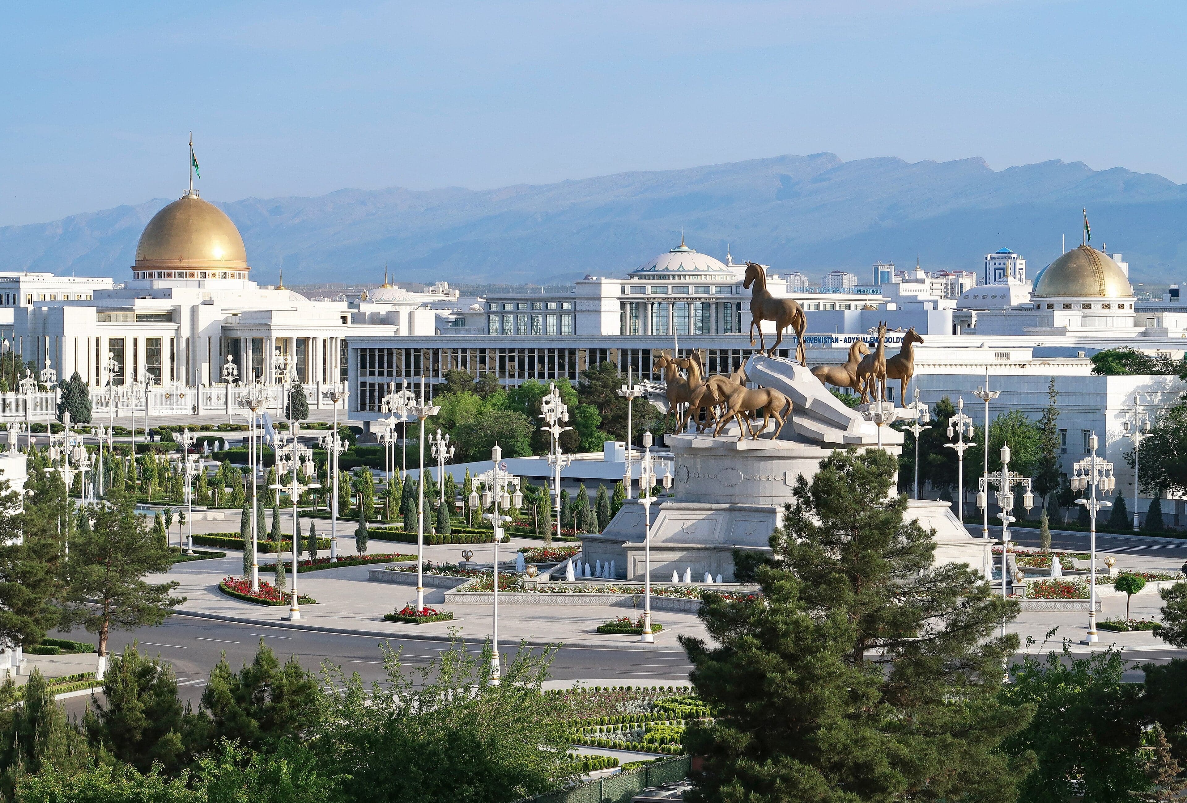 Wide white marble boulevards and gleaming marble buildings in Ashgabat at dusk