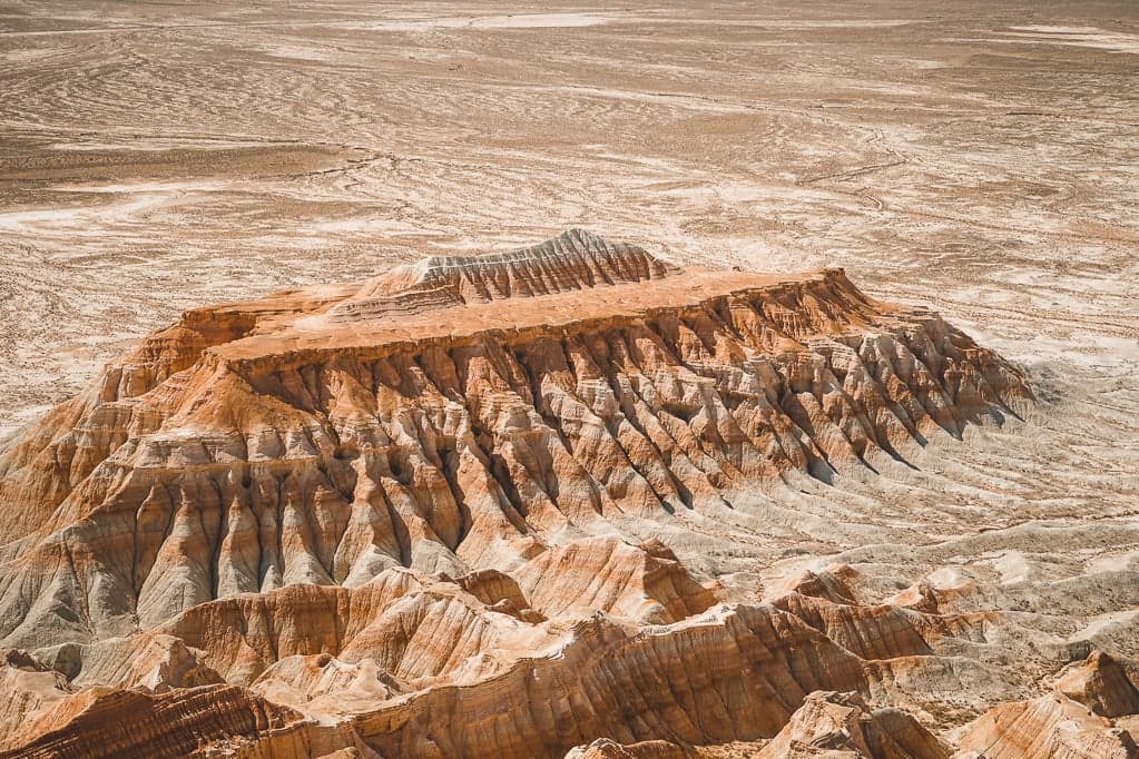 Layered pink, orange and white cliffs of Yangykala Canyon glowing in afternoon light