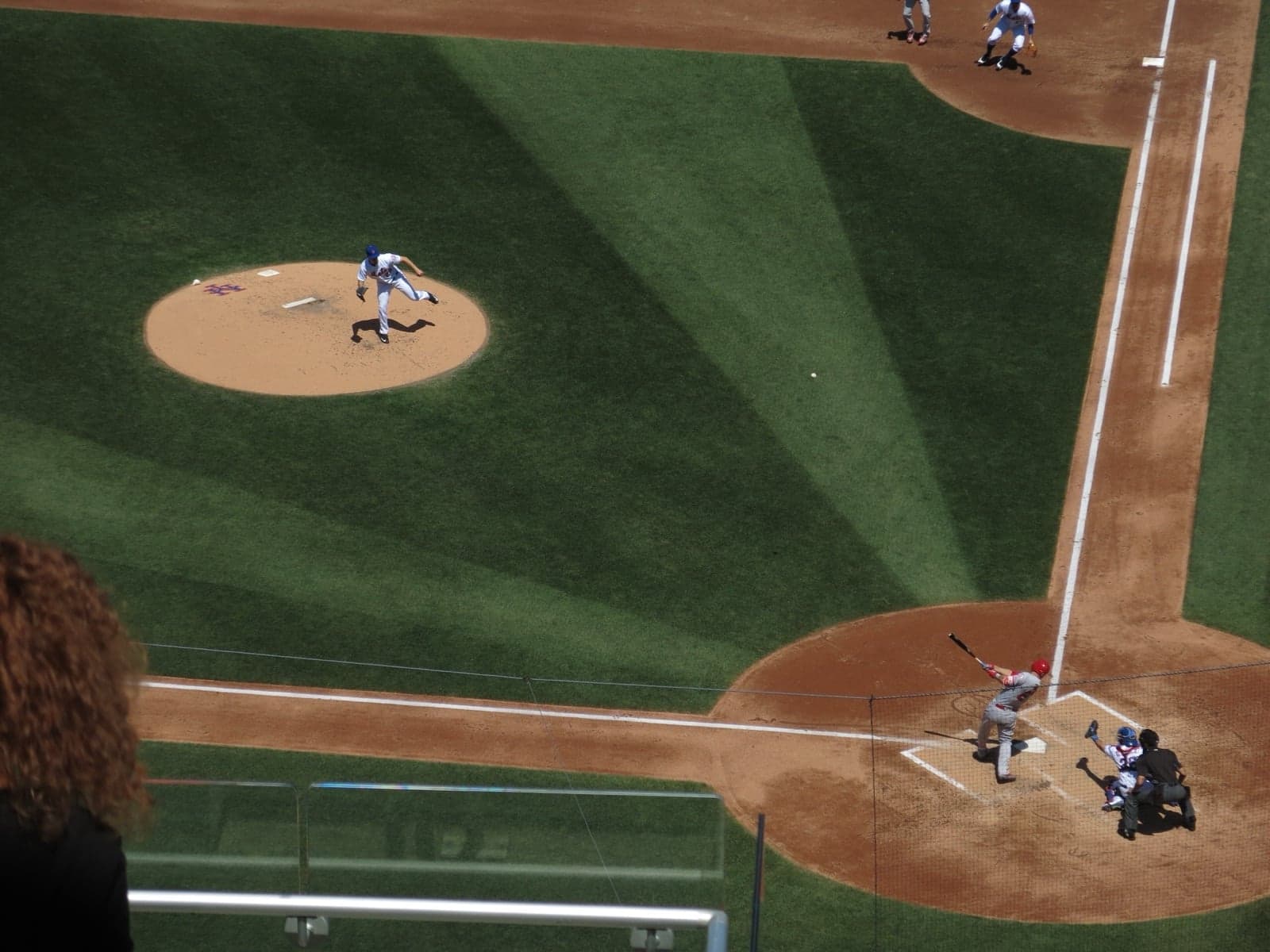 A baseball game in progress with the pitcher throwing the ball